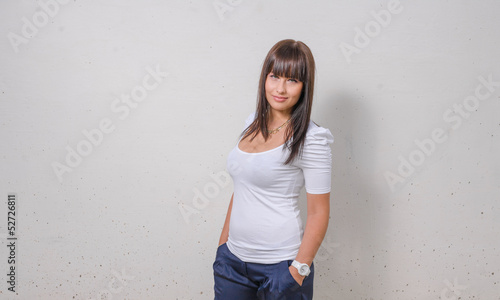 Photo: pretty girl standing in front of wall pretty girl standing in front of wall