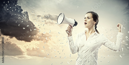 Photo: Businesswoman screaming in megaphone Businesswoman screaming in megaphone