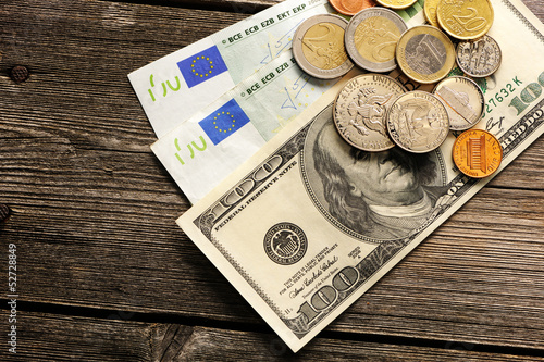 Photo: US and euro money over wooden background US and euro money over wooden background
