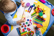 little boy painting at the table, top view