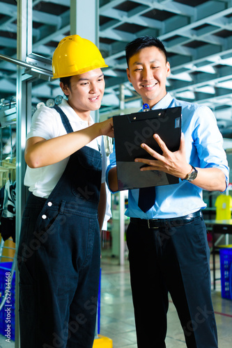 Photo: Worker and production manager with Clipboard Worker and production manager with Clipboard
