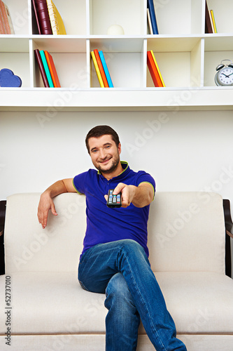 Photo: man resting on sofa and watching tv man resting on sofa and watching tv