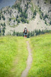 Girl with backpack walking, trekking up a mountain