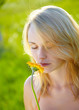 Photo: Blond girl take a smell at a flower, melancholy Blond girl take a smell at a flower, melancholy