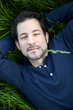 Photo: beautiful young man lying on green gras beautiful young man lying on green gras