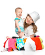Mom and baby girl with suitcase and clothes ready for traveling