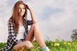 young beautiful brunette woman sitting on grass