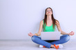 Beautiful young woman sitting with laptop in room