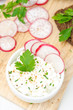 soft cottage cheese with radish and chives in a bowl, top view