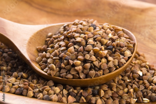 Photo: Buckwheat seeds on wooden spoon in closeup Buckwheat seeds on wooden spoon in closeup