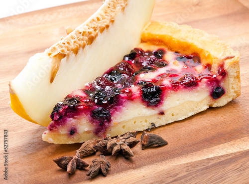 Photo: Cheesecake with berries and a fresh melon on a wooden tray Cheesecake with berries and a fresh melon on a wooden tray