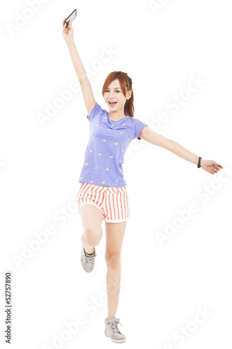 Photo: happy girl jumping with smart phone in the hand happy girl jumping with smart phone in the hand