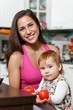 Mother with child in the kitchen.