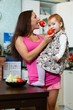 Mother with child in the kitchen.