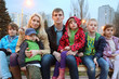 Big happy family in the evening sitting on the bench.