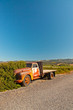 Photo: Old rusty pickup truck standing in winery landscape with blue sk Old rusty pickup truck standing in winery landscape with blue sk