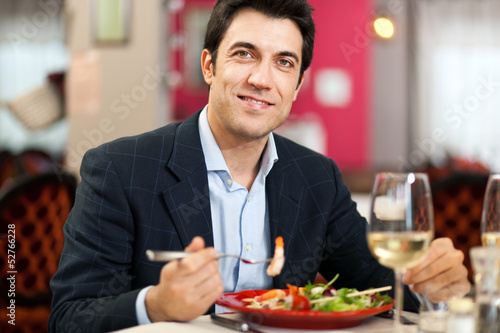 Photo: Handsome man eating at the restaurant Handsome man eating at the restaurant