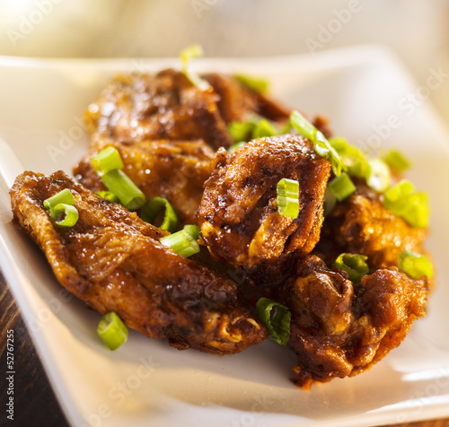 Photo: pile of chicken wings on plate. pile of chicken wings on plate.
