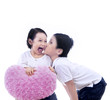 Boy kiss girl with heart pillow - isolated