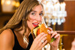 Photo: Young woman in fine restaurant, she eats a burger Young woman in fine restaurant, she eats a burger