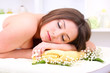 Beautiful young woman lying in spa salon close up