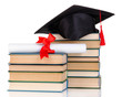 Grad hat with diploma and books isolated on white