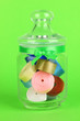 Glass jar containing various colored ribbons on green