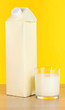 Milk pack on table on yellow background