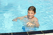 Activities on the pool. Cute boy swimming and playing in water i