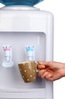 Woman filling cup at water cooler