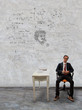man sitting on desk and physic formula on wall