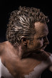 man covered in mud, naked, in profile, ancient warrior