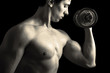Closeup of a muscular young man lifting weights