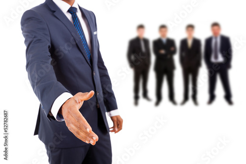 Photo: Business man offering handshake with businesspeople people on ba Business man offering handshake with businesspeople people on ba