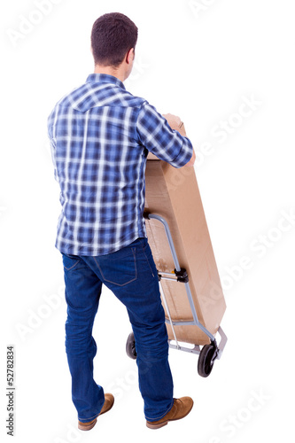 Photo: Young casual man moving a boxe with dolly, isolated on white bac Young casual man moving a boxe with dolly, isolated on white bac