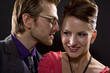 whispering couple on black background