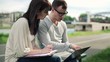 Young students with notepad and laptop computer in the city