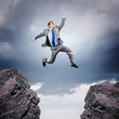 Businessman jumping over gap