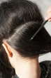 Closeup of combing back side hair part with selective focus