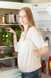 long-haired woman near opened refrigerator
