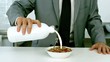 Well dressed businessman pouring milk into his cereals