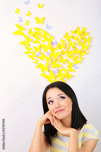 Photo: Girl near paper butterflies fly on wall Girl near paper butterflies fly on wall