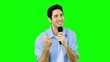 Man singing into microphone with emotion on green screen