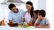 Mother showing children how to chop vegetables