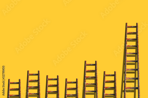 Photo: Old ladders on blank yellow wall Old ladders on blank yellow wall