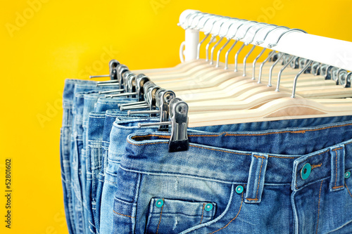 Photo: Row of hanged blue jeans in a shop Row of hanged blue jeans in a shop