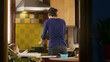 Multi-tasking mom cooking, working, feeding child in kitchen