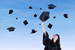 Asian graduate throw graduation cap in air