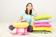 Foto: Beautiful young girl with pillows and book in room Beautiful young girl with pillows and book in room