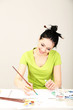 Photo: Beautiful young woman painter at work, on color background Beautiful young woman painter at work, on color background